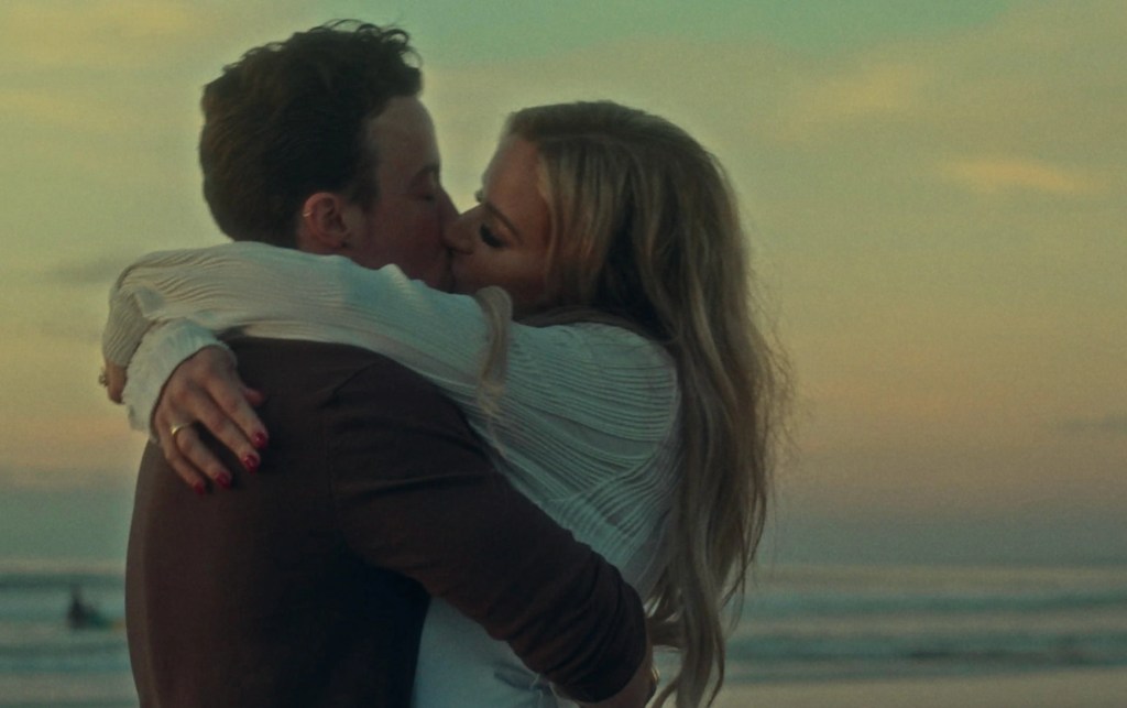 Couple embracing at sunset filmed by a San Diego wedding videographer during their beach wedding