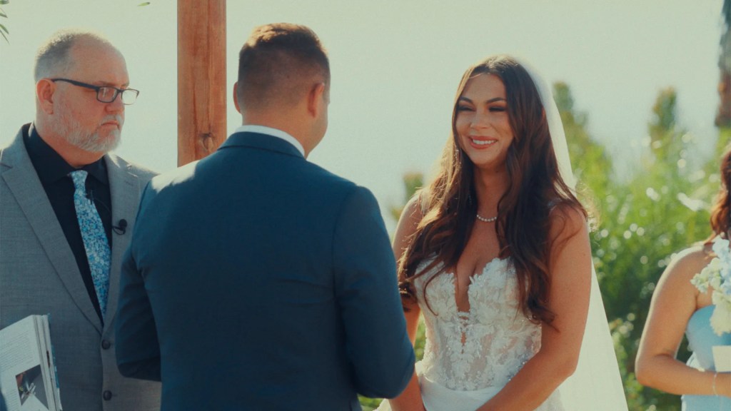Bride and groom smiling at outdoor ceremony – example of San Diego wedding video styles in cinematic format